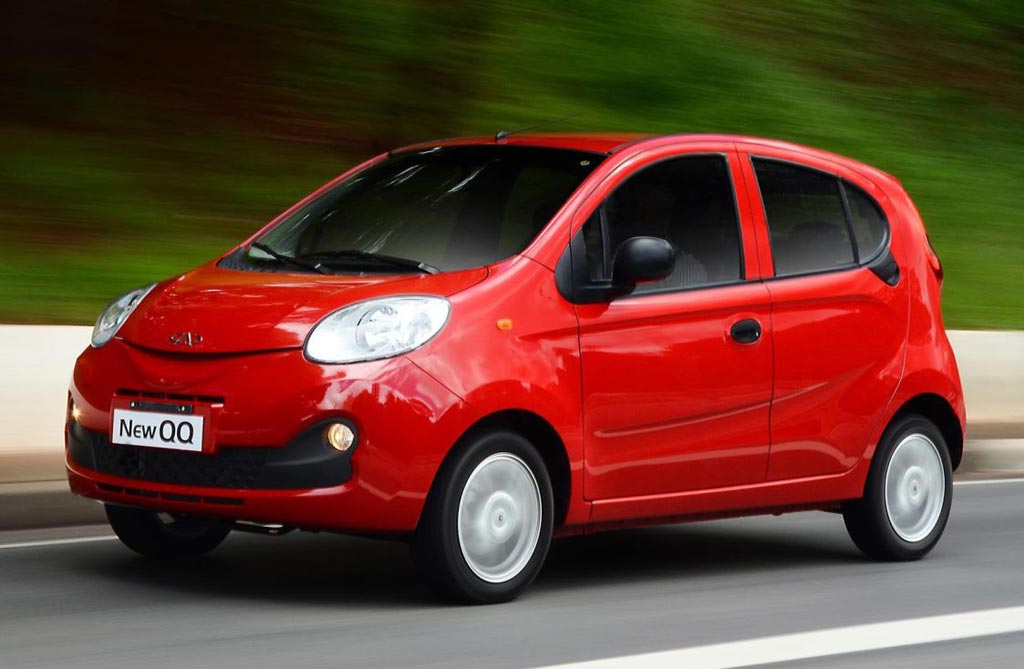 Chery QQ rojo circulando por la ruta, representando autos chinos compactos que están ganando mercado en Uruguay.