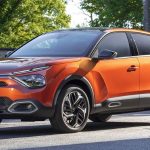 Citroen C4 naranja estacionado, exhibiendo su diseño crossover, altura elevada y características clave de la línea Citroen C4.