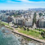 Vista aérea de Montevideo junto a la rambla, reflejando el entorno urbano donde se calculan los costos de tener un auto.