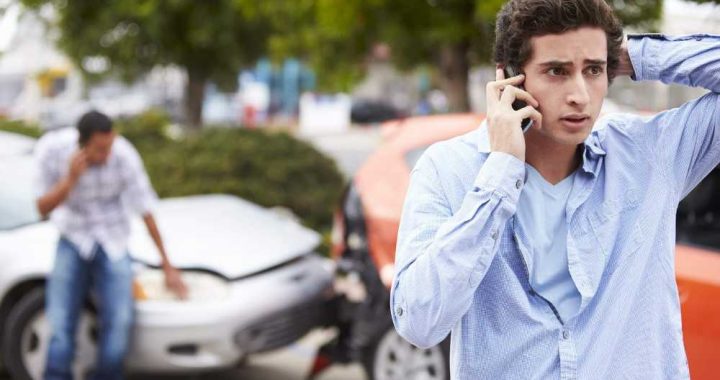 Conductor llamando por teléfono junto a su vehículo averiado para denunciar un siniestro dentro de los plazos establecidos.Conductor llamando por teléfono junto a su vehículo para denunciar un siniestro dentro de los plazos establecidos.